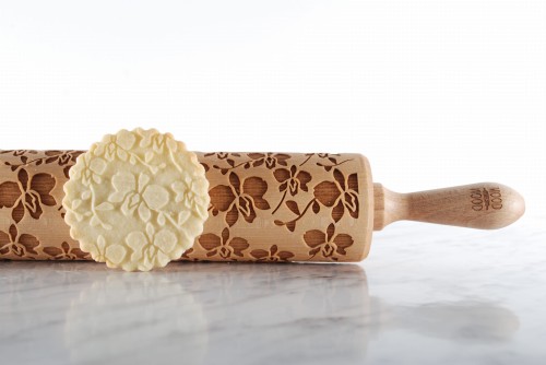 engraved wooden rolling pin orchid motif on kitchen counter