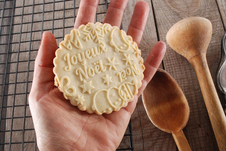 Wytłaczane ciastko we wzór świąteczny z francuskim napisem Joyeux Noel